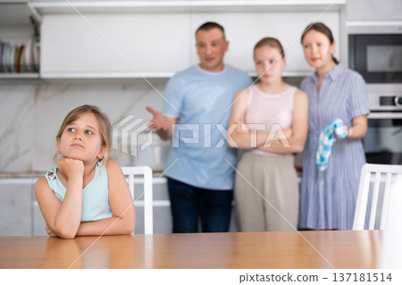 Frustrated tween girl listening to disgruntled parents reprimand 137181514