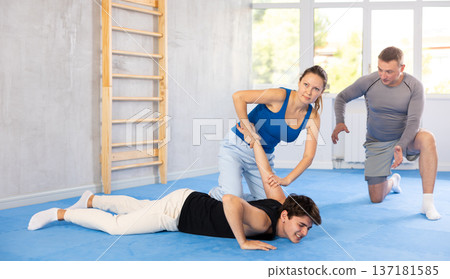 Woman learns to make power grab against male attacker under guidance of trainer. Self-defense class 137181585