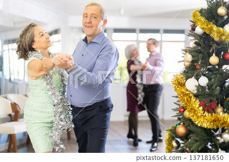In studio decorated for New Year, elderly man and woman perky dance pair discofox. In studio decorated for New Year, elderly man and woman perky dance pair discofox. 137181650