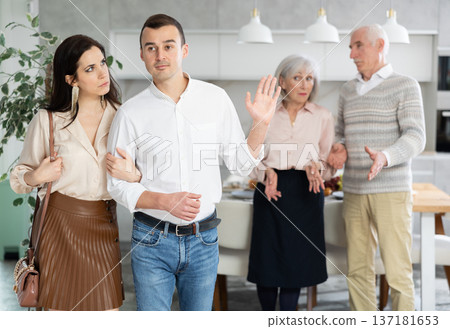 Disgruntled elderly parents accompany their son and daughter-in-law. Disgruntled elderly parents accompany their son and daughter-in-law. 137181653