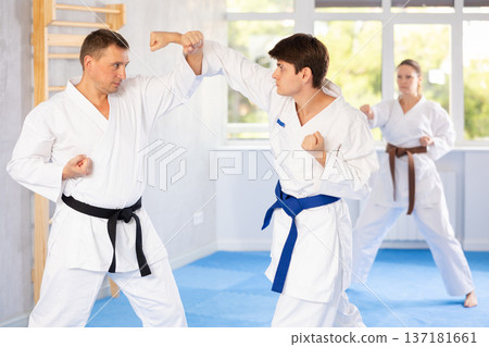 Two men are trained to perform basic defensive karate installations and attacking combat techniques Two men are trained to perform basic defensive karate installations and attacking combat techniques 137181661