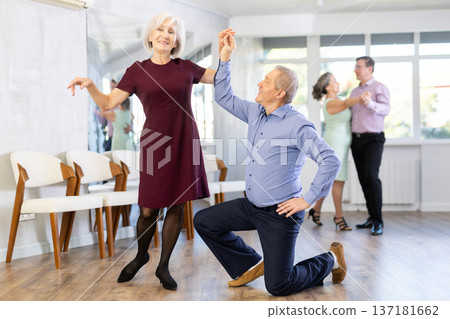 Senior man and elderly woman are dancing contemporary discofox in couple Senior man and elderly woman are dancing contemporary discofox in couple 137181662