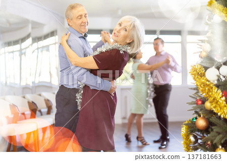 In studio decorated for New Year, elderly man and woman perky dance pair discofox. In studio decorated for New Year, elderly man and woman perky dance pair discofox. 137181663