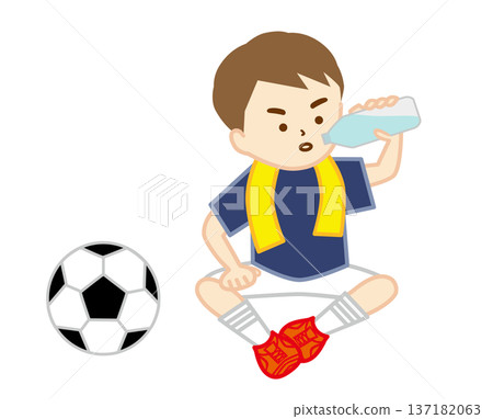 A soccer boy sitting on the ground with a towel around his neck to hydrate 137182063