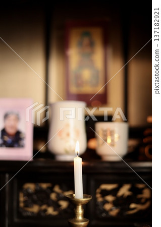 Lighted candles in brass candle holders in front of the Buddhist altar 137182921
