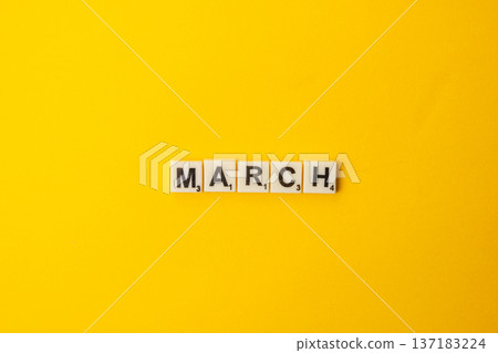 Celebration of National Scrabble Day with letter tiles on yellow background 137183224