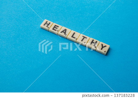 Scrabble tiles spell healthy on blue background for National Scrabble Day Scrabble tiles spell healthy on blue background for National Scrabble Day 137183228