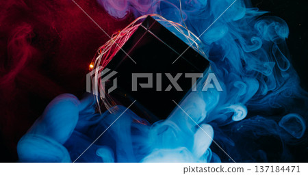 Colorful fog. Diamond frame. Blue red purple fume blend on glass crystal cube. Light garland abstract defocused ink black background. 137184471