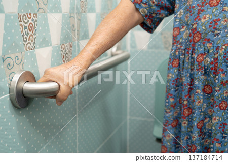 Asian elderly woman patient use toilet bathroom handle security in nursing hospital, healthy strong medical. 137184714