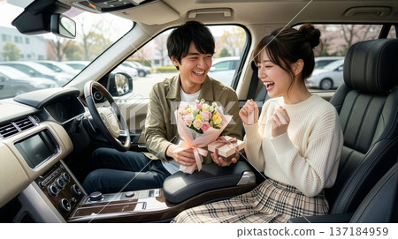 一名男子在車上向一名女子贈送白色情人節禮物。 137184959