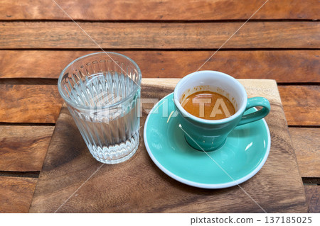 Beautiful unicorn latte art and a shot of espresso served on a wooden tray in a cafe. Beautiful unicorn latte art and a shot of espresso served on a wooden tray in a cafe. 137185025