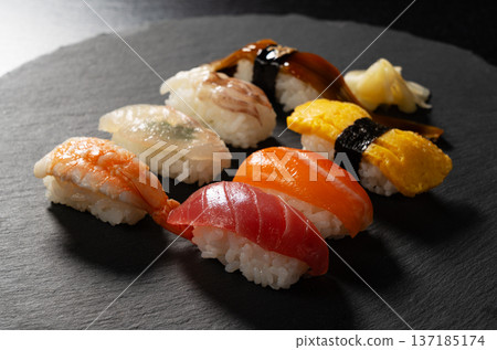 Assorted premium nigiri sushi served on a black stone plate 137185174