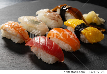 Assorted premium nigiri sushi served on a black stone plate Assorted premium nigiri sushi served on a black stone plate 137185178
