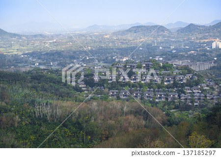 Aerial view of Sanya city with a sea bay surrounded by mountains on Hainan Island in China Aerial view of Sanya city with a sea bay surrounded by mountains on Hainan Island in China 137185297