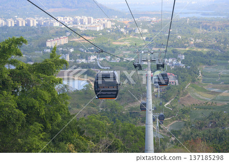 Cable car cabins above the forest and valley near the city of Sanya on Hainan Island in China 137185298
