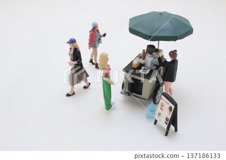 Miniature Figures Approach Coffee Cart Beneath Large Umbrella Miniature Figures Approach Coffee Cart Beneath Large Umbrella 137186133