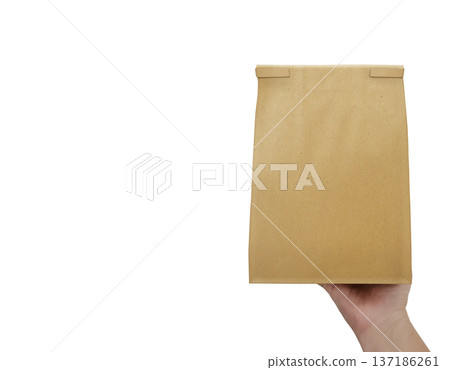 The man is holding an empty brown paper bag in his hand, with space left for an advertising message. The man is holding an empty brown paper bag in his hand, with space left for an advertising message. 137186261