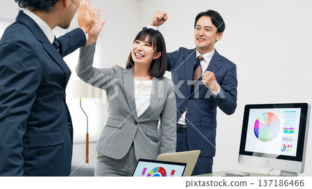一群商務人士在辦公室擊掌慶祝 一群商務人士在辦公室擊掌慶祝 137186466