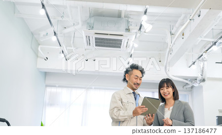 A worker explaining using a tablet in the office A worker explaining using a tablet in the office 137186477