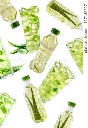 Multiple glasses and bottles with green aloe drink and cubes isolated on white background, concept of freshness Multiple glasses and bottles with green aloe drink and cubes isolated on white background, concept of freshness 137186727