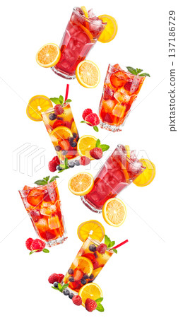 Savor a refreshing iced raspberry beverage with fruit and mint under the warm summer sun 137186729