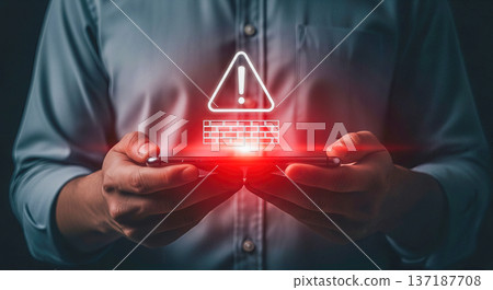 Man hands holding smartphone with glowing red warning triangle and brick wall hologram for mobile cybersecurity and firewall protection concept Man hands holding smartphone with glowing red warning triangle and brick wall hologram for mobile cybersecurity and firewall protection concept 137187708