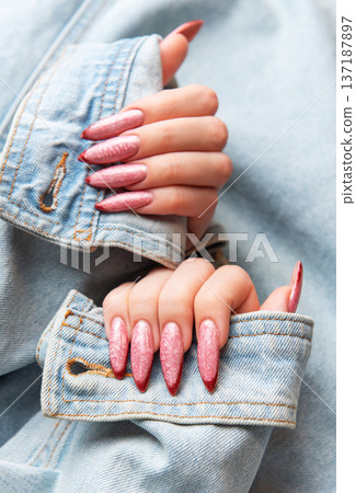 Woman showing trendy pink stiletto nails with denim jacket Woman showing trendy pink stiletto nails with denim jacket 137187897