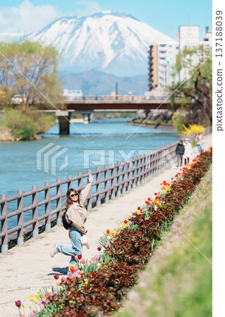 Woman tourist sightseeing Iwate mountain and Kitakami river with flowers in Spring, happy traveler travel in Morioka city, Iwate prefecture, Japan. famous Landmark Travel and Vacation destination 137188039