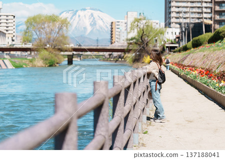 Woman tourist sightseeing Iwate mountain and Kitakami river with flowers in Spring, happy traveler travel in Morioka city, Iwate prefecture, Japan. famous Landmark Travel and Vacation destination Woman tourist sightseeing Iwate mountain and Kitakami river with flowers in Spring, happy traveler travel in Morioka city, Iwate prefecture, Japan. famous Landmark Travel and Vacation destination 137188041