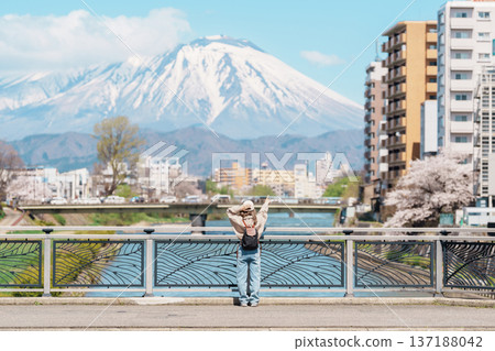 Woman tourist sightseeing Iwate mountain and Kitakami river with flowers in Spring, happy traveler travel in Morioka city, Iwate prefecture, Japan. famous Landmark Travel and Vacation destination Woman tourist sightseeing Iwate mountain and Kitakami river with flowers in Spring, happy traveler travel in Morioka city, Iwate prefecture, Japan. famous Landmark Travel and Vacation destination 137188042