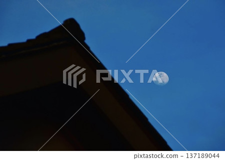 The moon rising from a tiled roof building The moon rising from a tiled roof building 137189044