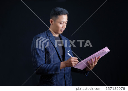 portrait of confident businessman in black suit 137189076