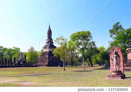 Ancient stone Buddha statue and ruins of ancient temple in Sukhothai historical park. Picturesque scene with Buddha statuary, Sukhothai old city, Northern Thailand. Topic of travel, trip, cruise, tour 137189804