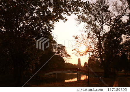 Sunset scene in Ayutthaya Historical Park, Thailand. Picturesque scene with old temple, rivet and trees, Ayutthaya old city. Topic of vacation, travel, trip, cruise, tour. Photo toned in yellow color 137189805