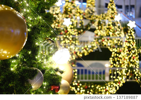 Christmas tree adorned with golden ornaments and twinkling lights, creating a festive atmosphere with blurred decorations in the background, embodying holiday spirit and celebration Christmas tree adorned with golden ornaments and twinkling lights, creating a festive atmosphere with blurred decorations in the background, embodying holiday spirit and celebration 137189887