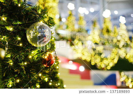 Christmas tree adorned with sparkling ornaments and lights, creating a festive atmosphere, ideal for New Years greeting cards with copy space for personalized messages Christmas tree adorned with sparkling ornaments and lights, creating a festive atmosphere, ideal for New Years greeting cards with copy space for personalized messages 137189893