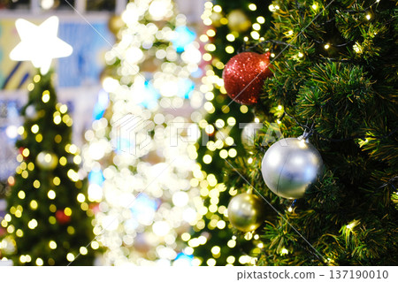 Christmas tree adorned with colorful ornaments and twinkling lights, creating a festive atmosphere for holiday celebrations and New Year greetings with copy space for text 137190010