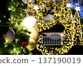 Christmas tree adorned with sparkling ornaments and bright lights, surrounded by festive decorations, creating a warm holiday atmosphere with copy space for text 137190019