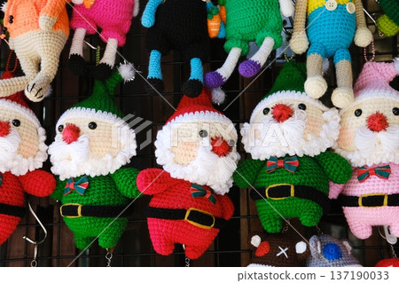 Handmade knitted toys featuring colorful Santa Claus figures in festive attire, perfect for Christmas and New Year celebrations, showcasing craftsmanship and holiday spirit 137190033