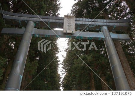 The gates to the Kitaguchi Hongu Sengen Jinja shrine, the entrance to the path to climb Mt. Fuji, lined with stone lanterns in Fujiyoshida in Yamanashi Japan on a snow covered winter day. The gates to the Kitaguchi Hongu Sengen Jinja shrine, the entrance to the path to climb Mt. Fuji, lined with stone lanterns in Fujiyoshida in Yamanashi Japan on a snow covered winter day. 137191075