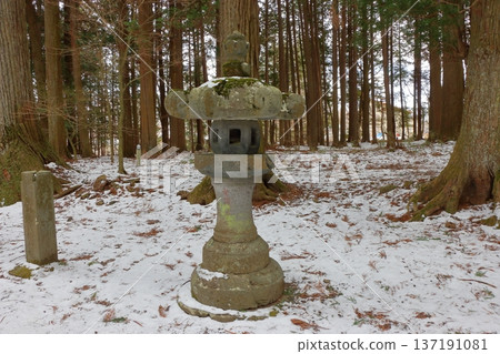 The long pathway to the Kitaguchi Hongu Sengen Jinja shrine, the entrance to the path to climb Mt. Fuji, lined with stone lanterns in Fujiyoshida in Yamanashi Japan on a snow covered winter day. The long pathway to the Kitaguchi Hongu Sengen Jinja shrine, the entrance to the path to climb Mt. Fuji, lined with stone lanterns in Fujiyoshida in Yamanashi Japan on a snow covered winter day. 137191081