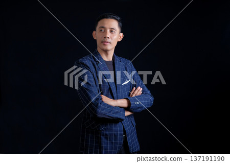 portrait of confident handsome elegant responsible businessman posing on black background 137191190
