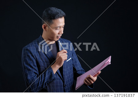 Portrait of handsome elegant man in black suit on black background. Studio mode portrait Portrait of handsome elegant man in black suit on black background. Studio mode portrait 137191837