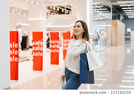 Fashionable Female Customer Looking Away with Purchased Goods 137192030