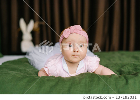 Baby Girl In Pink Headband Crawling On Green Blanket Baby Girl In Pink Headband Crawling On Green Blanket 137192031