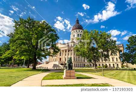 Scenic sunny view of the seated Abraham Lincoln statue on the lush green grounds of the historic Kansas State Capitol building in Topeka, United States 137193303