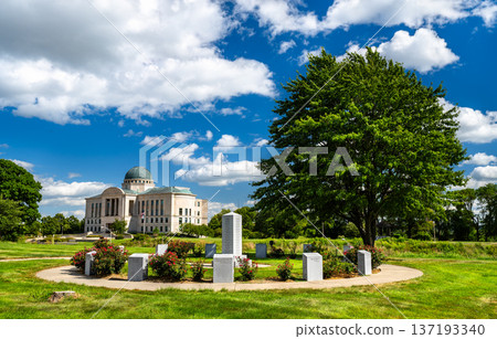 Scenic sunny view of the circular Iowa Revolutionary War Monument and the domed Iowa Judicial Branch Building on the lush State Capitol grounds in Des Moines, United States 137193340