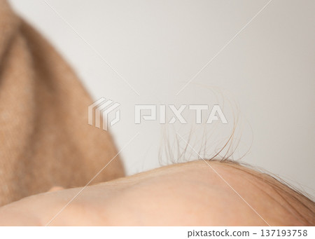 Close-up shot of soft newborn hair lit by gentle natural light. Neutral tones and minimal composition create a clean, calm aesthetic perfect for parenting, maternity, baby care, and lifestyle themes 137193758