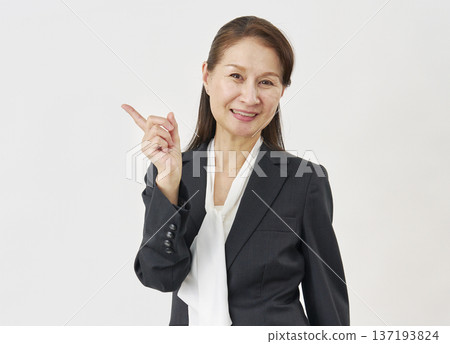 Woman pointing to the left on a white background 137193824