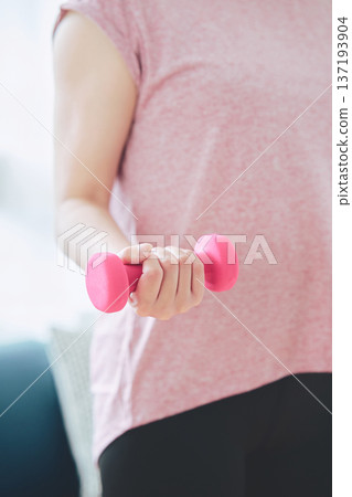 特寫鏡頭：一位女士在家做啞鈴運動時，手臂特寫。 137193904